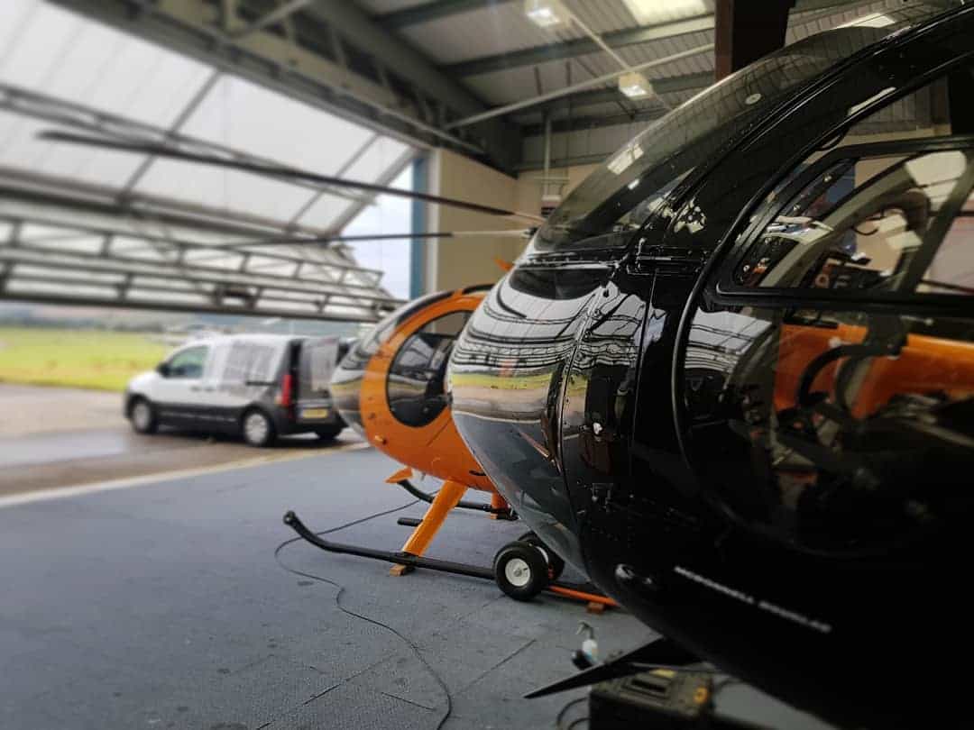 Helicopters in the hangar with the MAX WAX van during aircraft cleaning