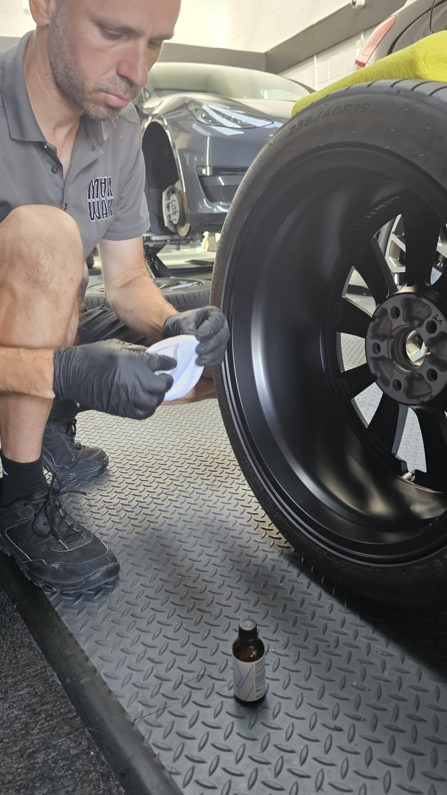 Alloy wheel refurbishment prep - MAX WAX technician with the wheel off the car at our Shoreham workshop