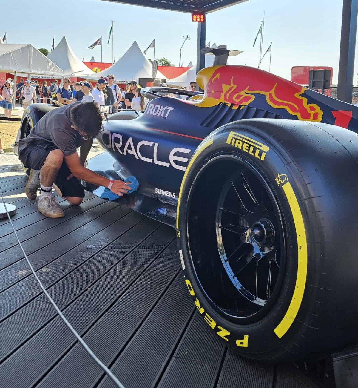 MAX WAX technician detailing a Formula 1 show car at a public event