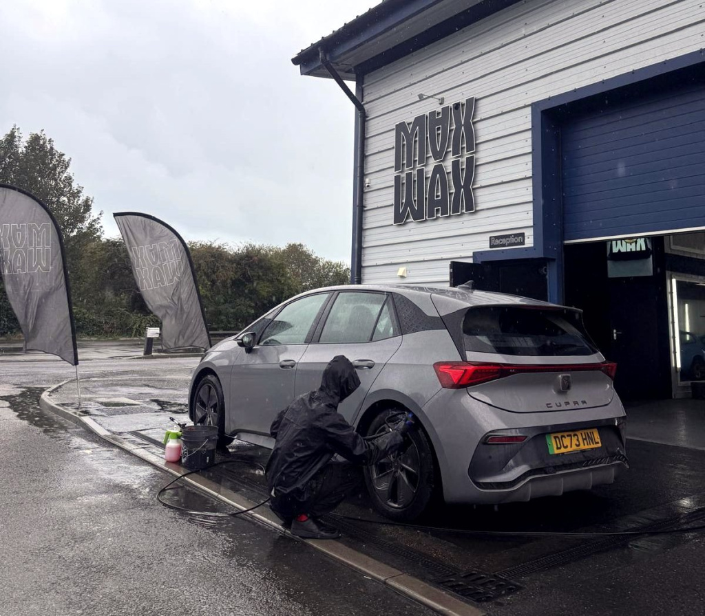 MAX WAX technician washing a car in the rain outside the Shoreham HQ