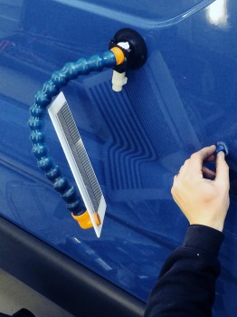 PDR technician removing dent from commercial vehicle